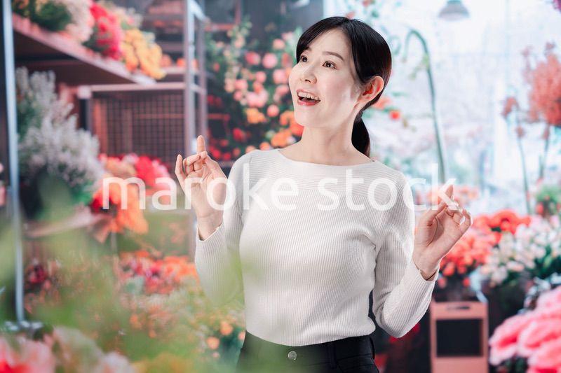 お花屋さんで花を選ぶ若い女性