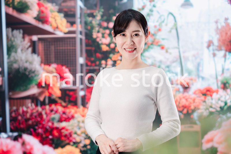 お花屋さんで花を選ぶ若い女性