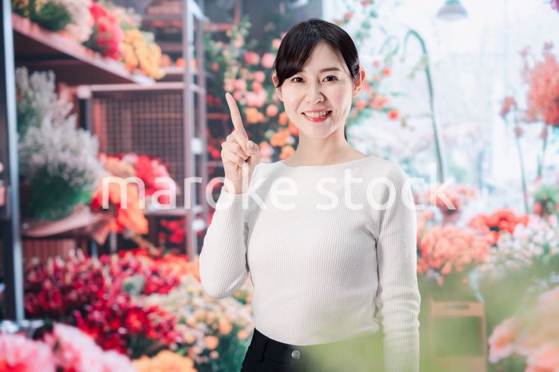 お花屋さんで花を選ぶ若い女性