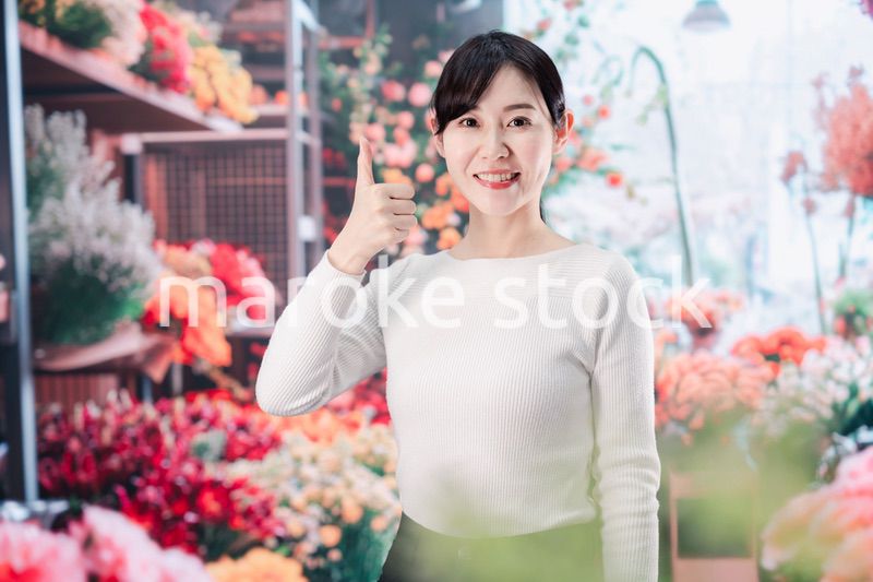 お花屋さんで花を選ぶ若い女性