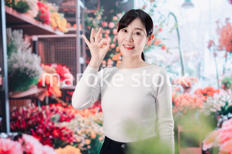 お花屋さんで花を選ぶ若い女性