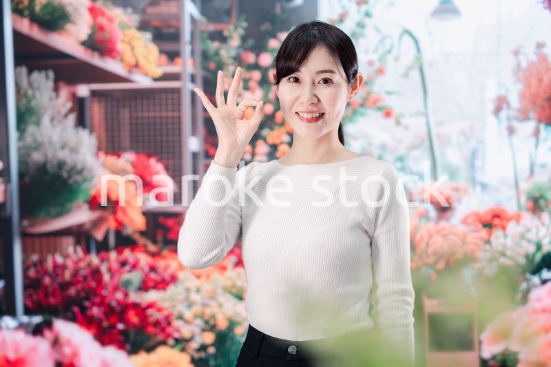 お花屋さんで花を選ぶ若い女性