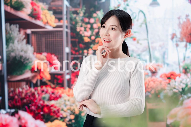 お花屋さんで花を選ぶ若い女性