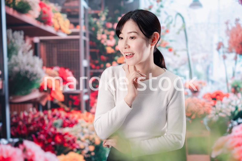お花屋さんで花を選ぶ若い女性