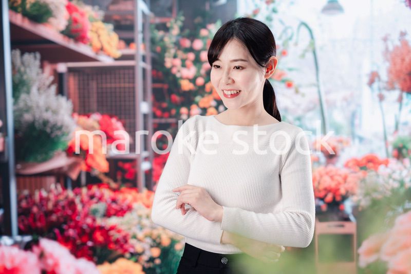 お花屋さんで花を選ぶ若い女性