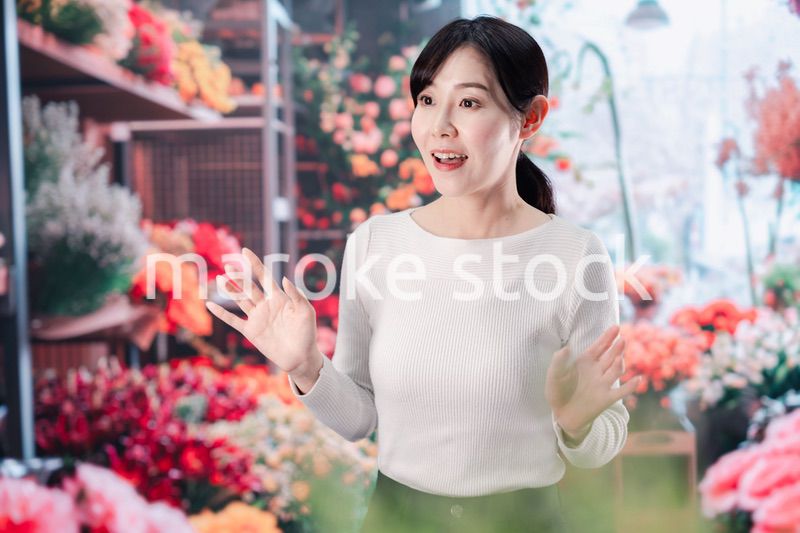 お花屋さんで花を選ぶ若い女性