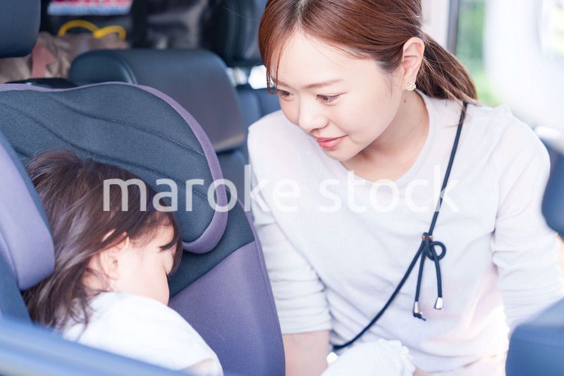 車でお出かけをする小さな子供とお母さん