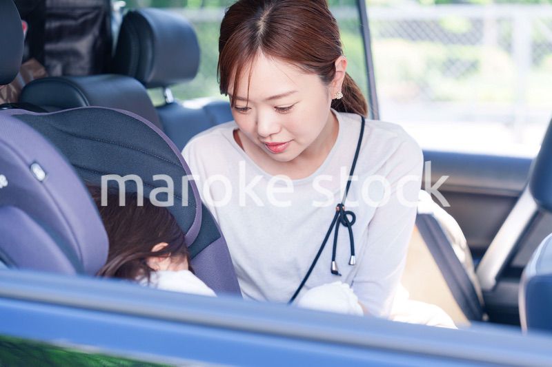 車でお出かけをする小さな子供とお母さん