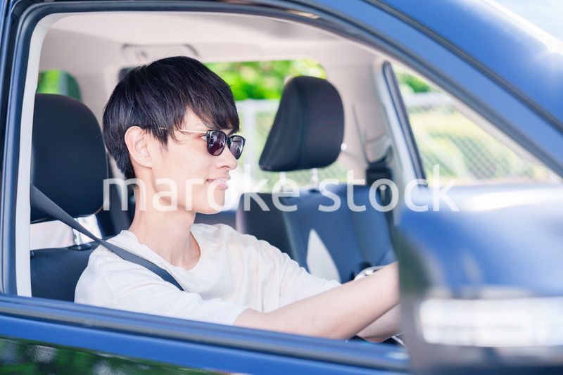 車のドライブを楽しむ若い男性
