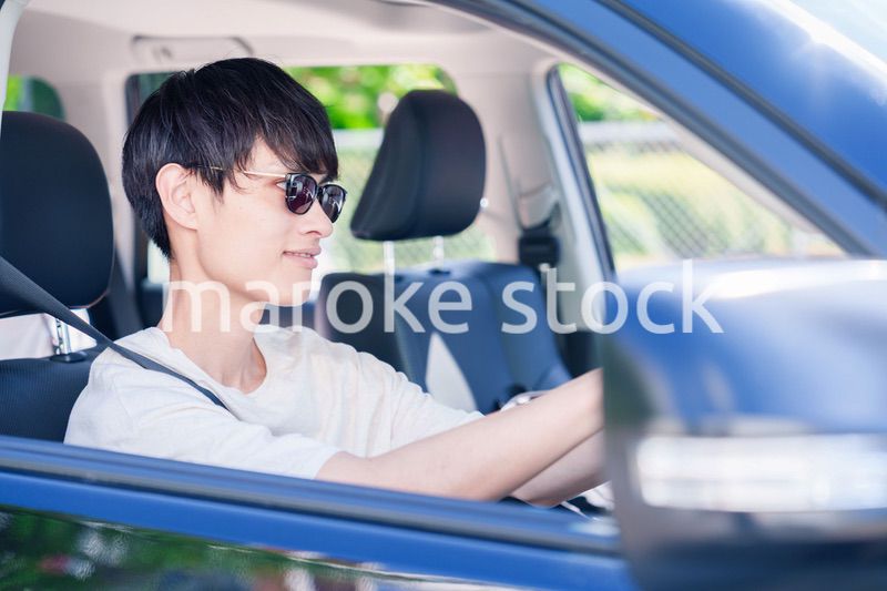 車のドライブを楽しむ若い男性