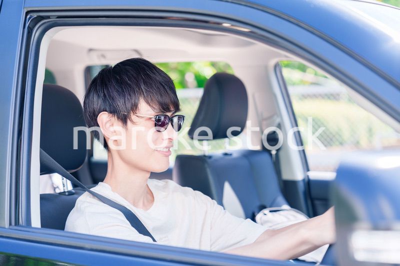 車のドライブを楽しむ若い男性