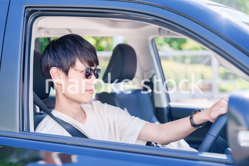 車のドライブを楽しむ若い男性