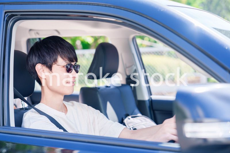車のドライブを楽しむ若い男性