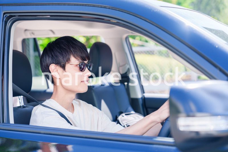 車のドライブを楽しむ若い男性