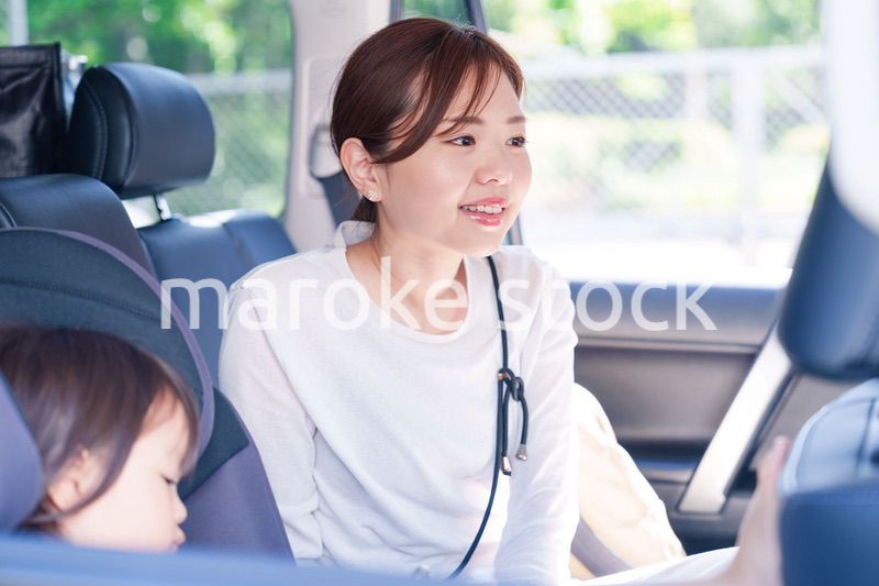 車でお出かけをする小さな子供とお母さん