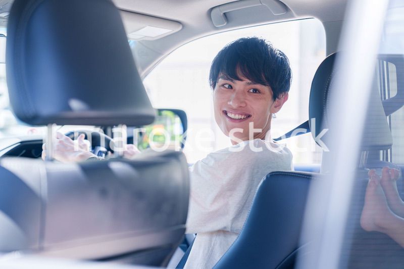 車のドライブを楽しむ若い男性