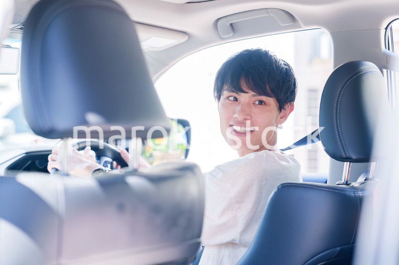 車のドライブを楽しむ若い男性