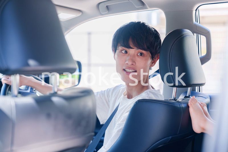 車のドライブを楽しむ若い男性