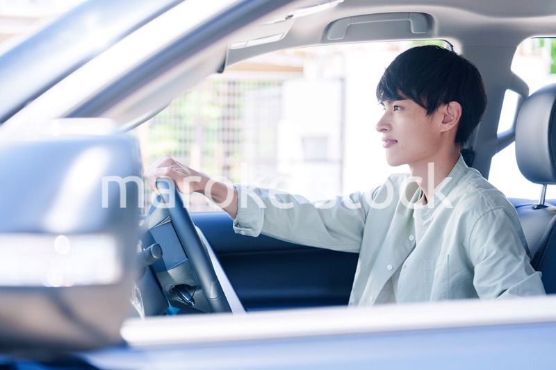 車のドライブを楽しむ若い男性