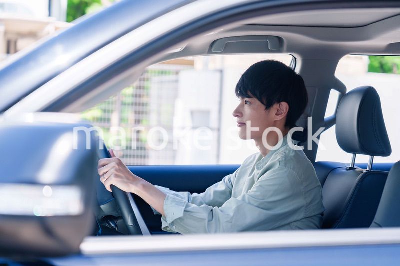 車のドライブを楽しむ若い男性