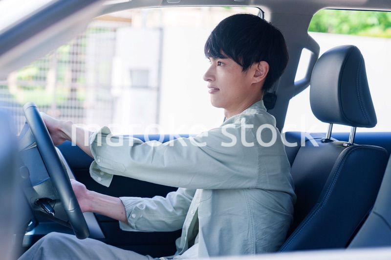 車のドライブを楽しむ若い男性