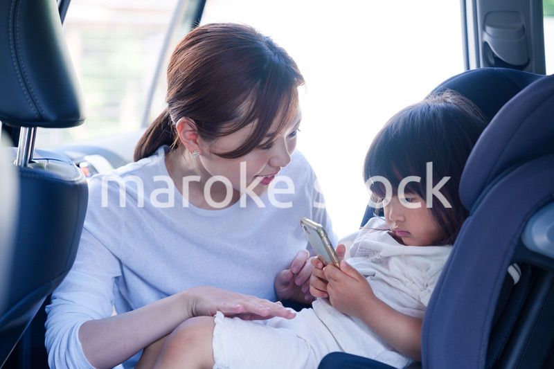 車でお出かけをする小さな子供とお母さん