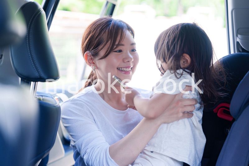 車でお出かけをする小さな子供とお母さん