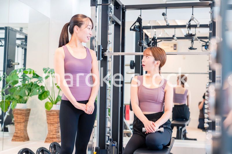 ジムで女性コーチのパーソナルトレーニングを受ける女性