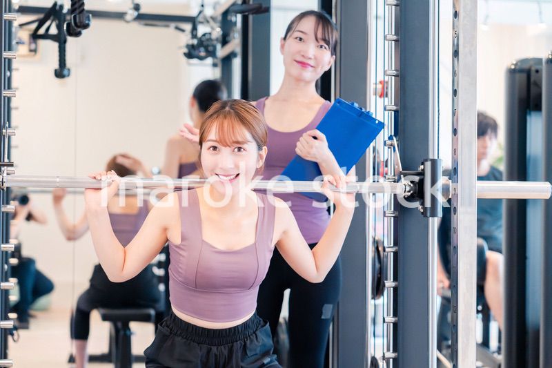 ジムで女性コーチのパーソナルトレーニングを受ける女性
