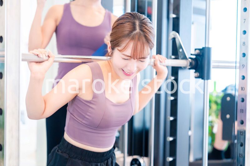 ジムで女性コーチのパーソナルトレーニングを受ける女性