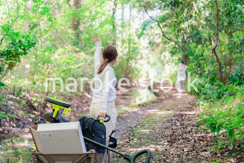 森の中でアウトドアカートを使う家族