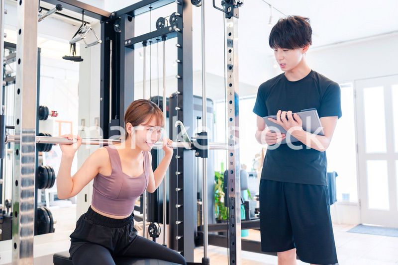 パーソナルジムに通う女性とトレーナー