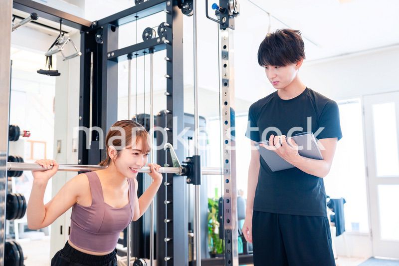 パーソナルジムに通う女性とトレーナー