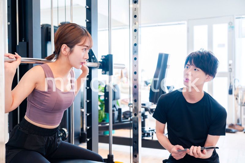 パーソナルジムに通う女性とトレーナー