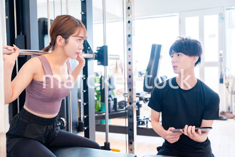 パーソナルジムに通う女性とトレーナー