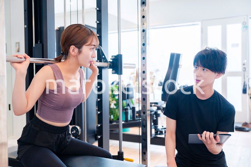 パーソナルジムに通う女性とトレーナー