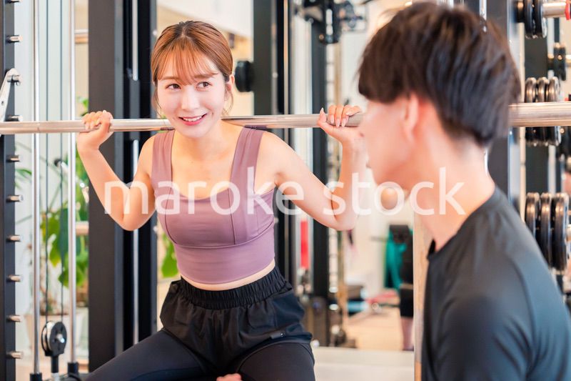 パーソナルジムに通う女性とトレーナー