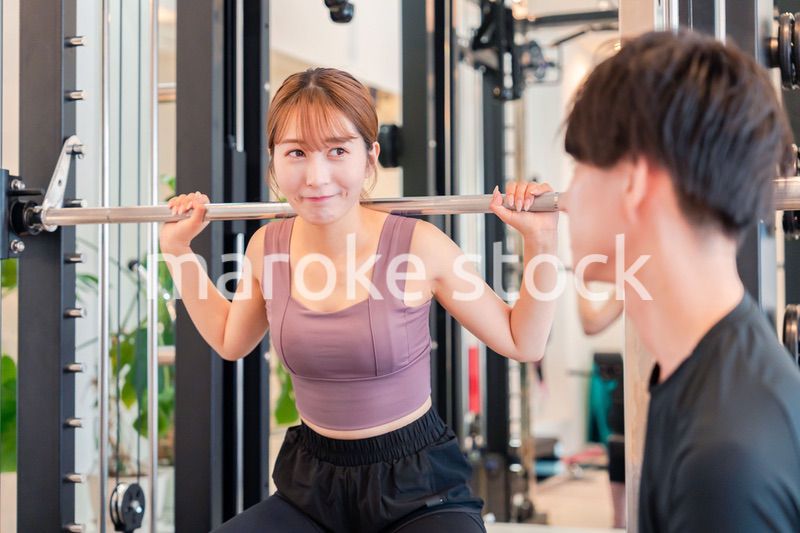 パーソナルジムに通う女性とトレーナー
