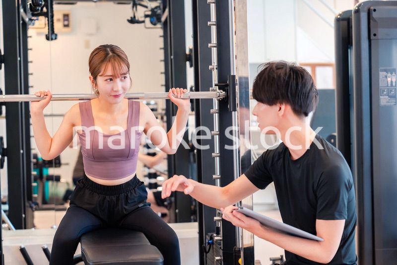 パーソナルジムに通う女性とトレーナー