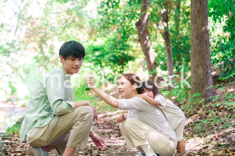 自然の中で虫除けスプレーを使うファミリー