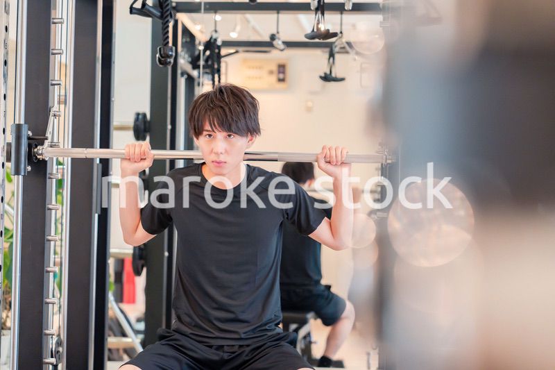 ジムで筋トレをする若い男性