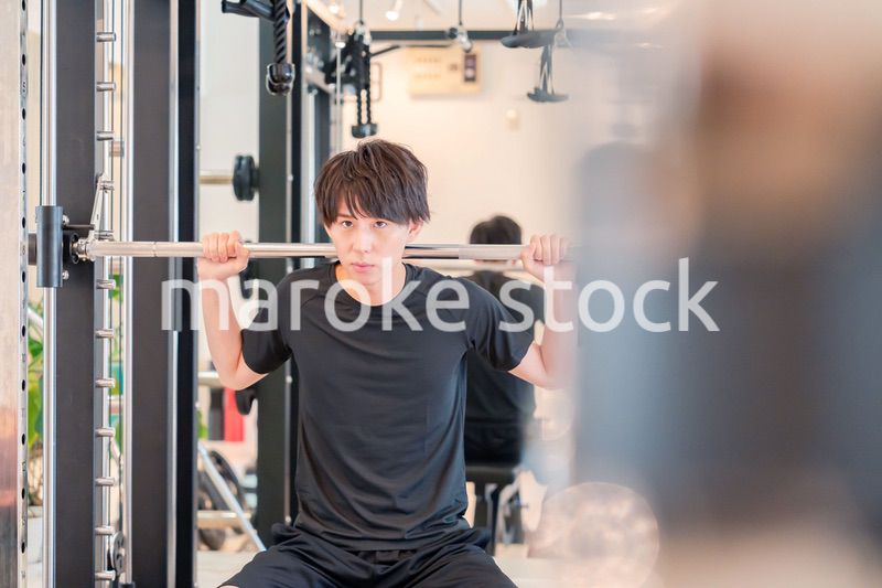 ジムで筋トレをする若い男性
