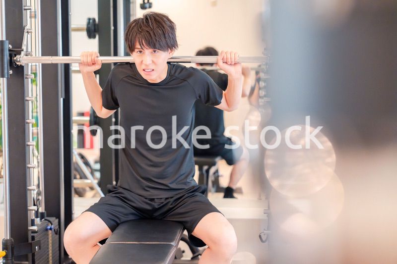 ジムで筋トレをする若い男性