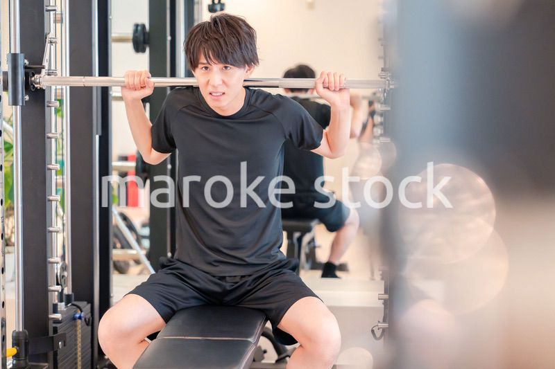 ジムで筋トレをする若い男性