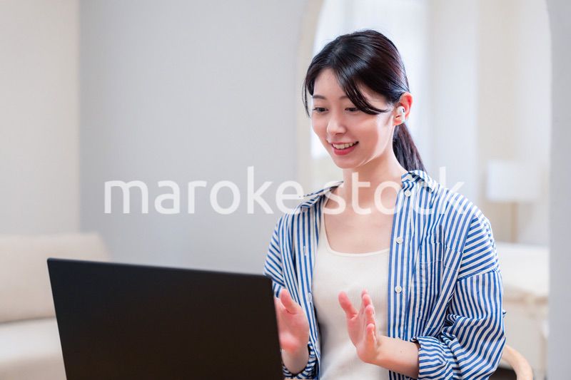 在宅でリモート会議に参加する若い女性社員