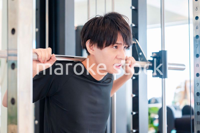 ジムで筋トレをする若い男性