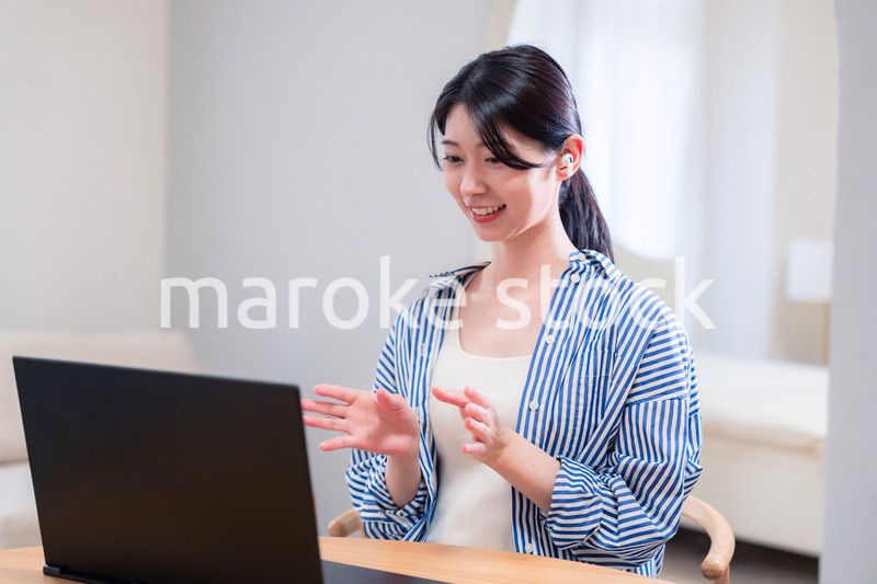 在宅でリモート会議に参加する若い女性社員