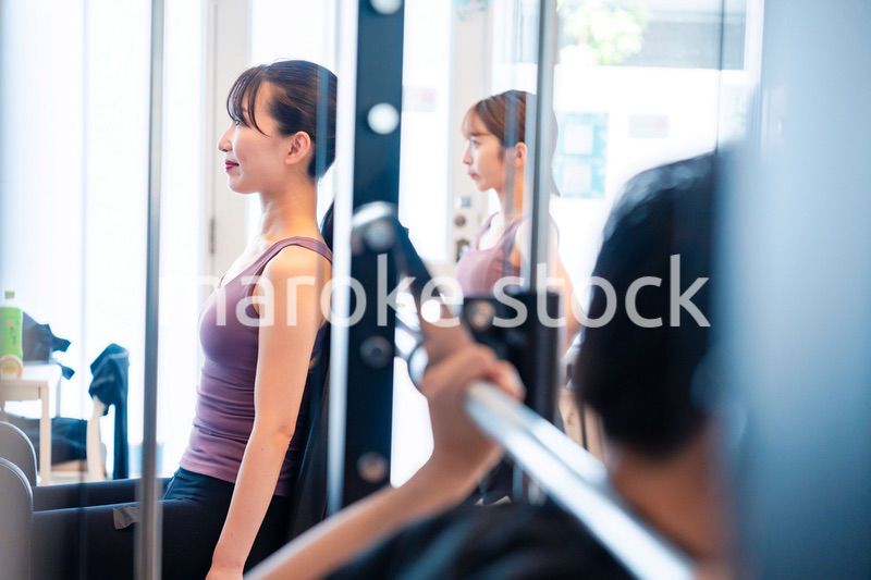 ジムのマシーンでトレーニングをする人