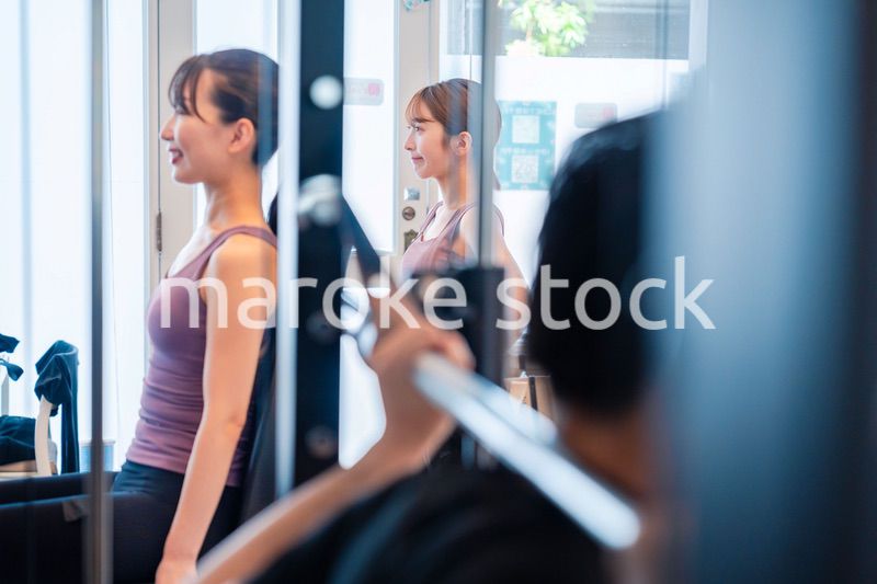 ジムのマシーンでトレーニングをする人