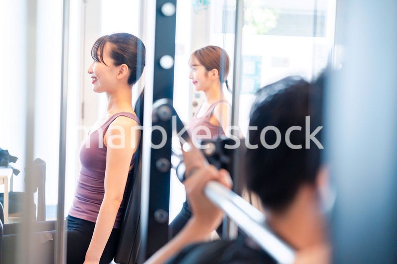 ジムのマシーンでトレーニングをする人